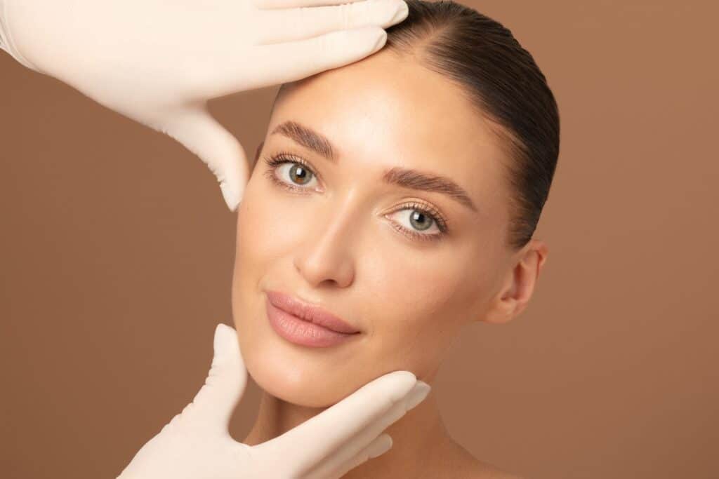 Close up of a doctor touching a woman's sculpted face after she received a mini facelift