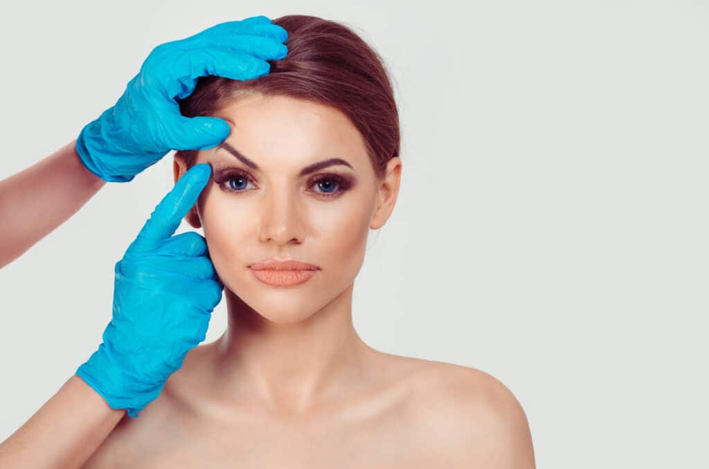Woman having a consultation with her surgeon for a brow lift to correct asymmetry