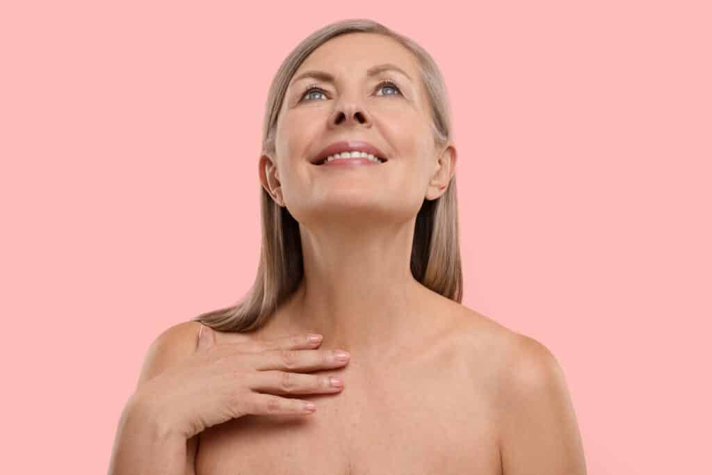 Headshot of an older woman looking up and showing her sharp, defined jawline after neck lift or liposuction