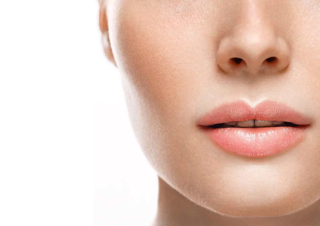 Close up of a woman's face with full, smooth lips after lip augmentation